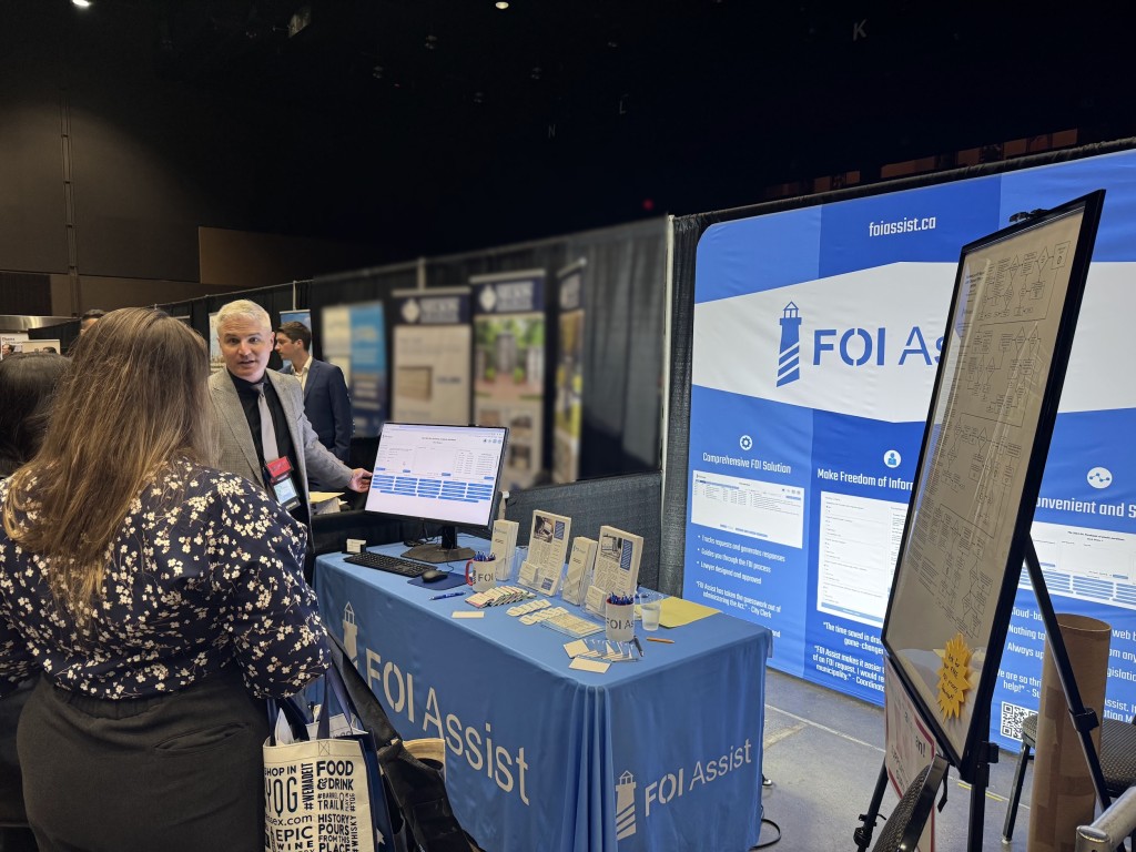 Justin Petrillo shows a conference attendee the FOI Assist software at an exhibit booth.