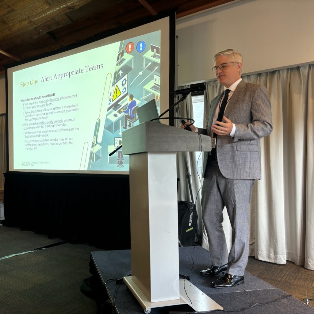 FOI Assist Corporation President Justin Petrillo speaking at a dais.